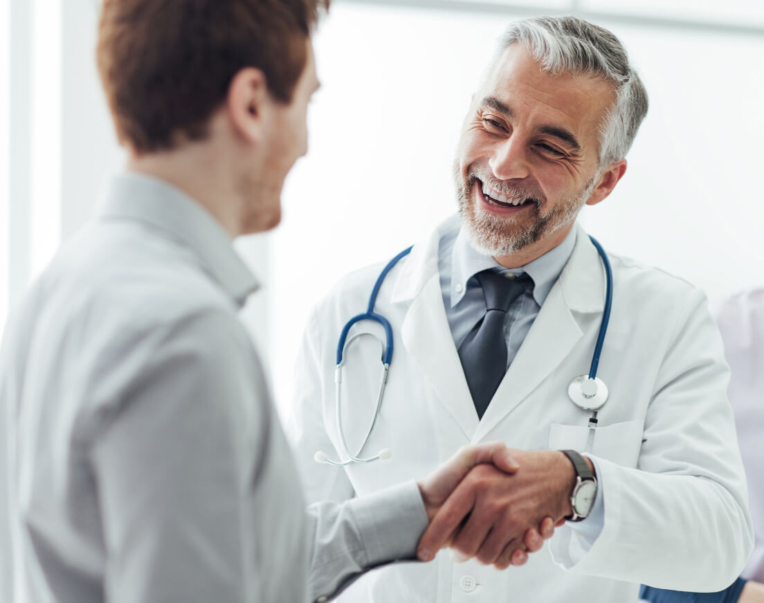 Smiling doctor shaking hands with patient