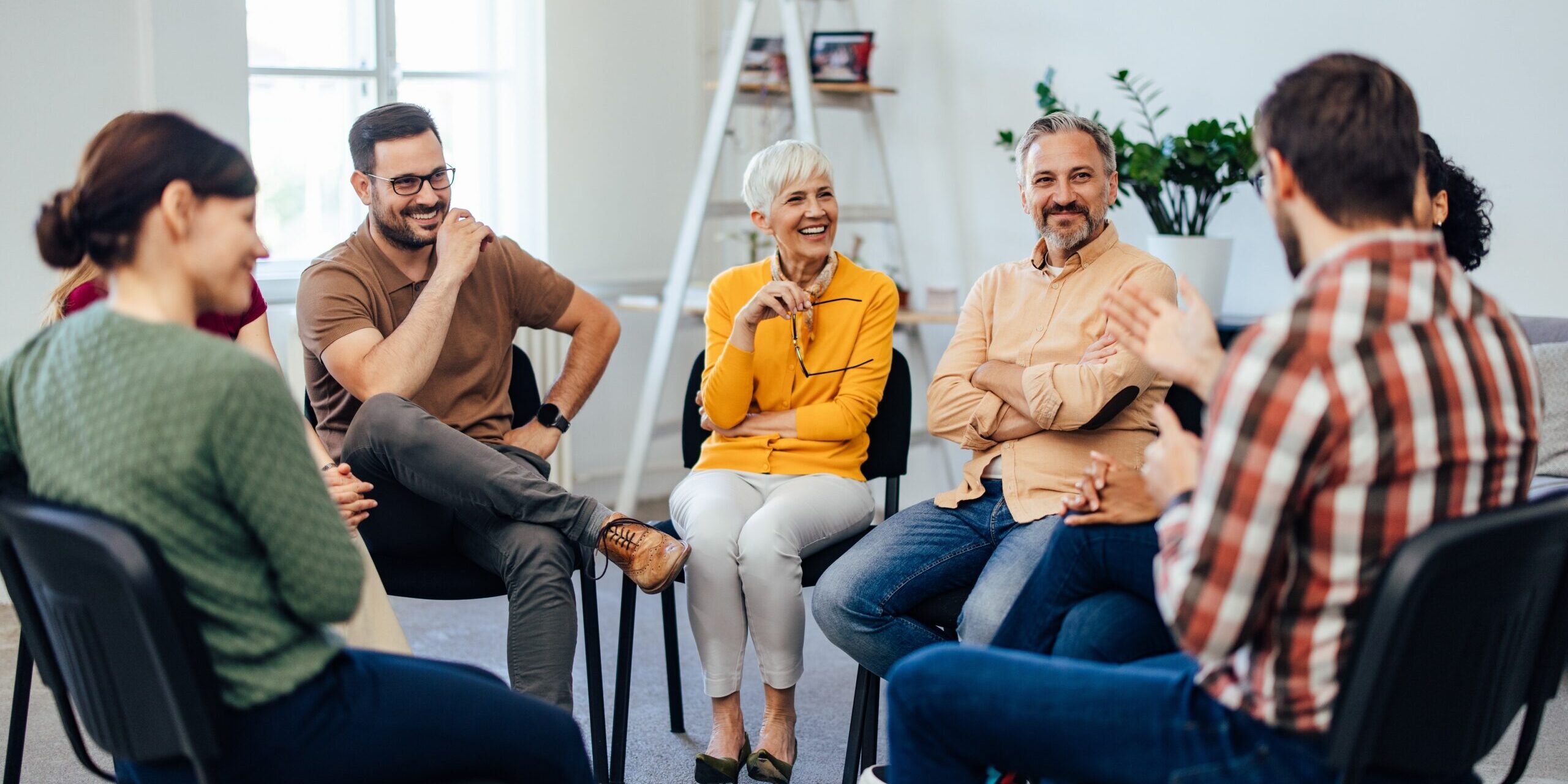 People sitting in a support circle talking and laughing